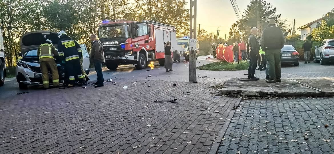 Motocykl zderzył się z osobówką w Nowych Grochalach Strażacy przy rozbitym samochodzie osobowym, w tle wóz strażacki na drodze w Nowych Grochalach